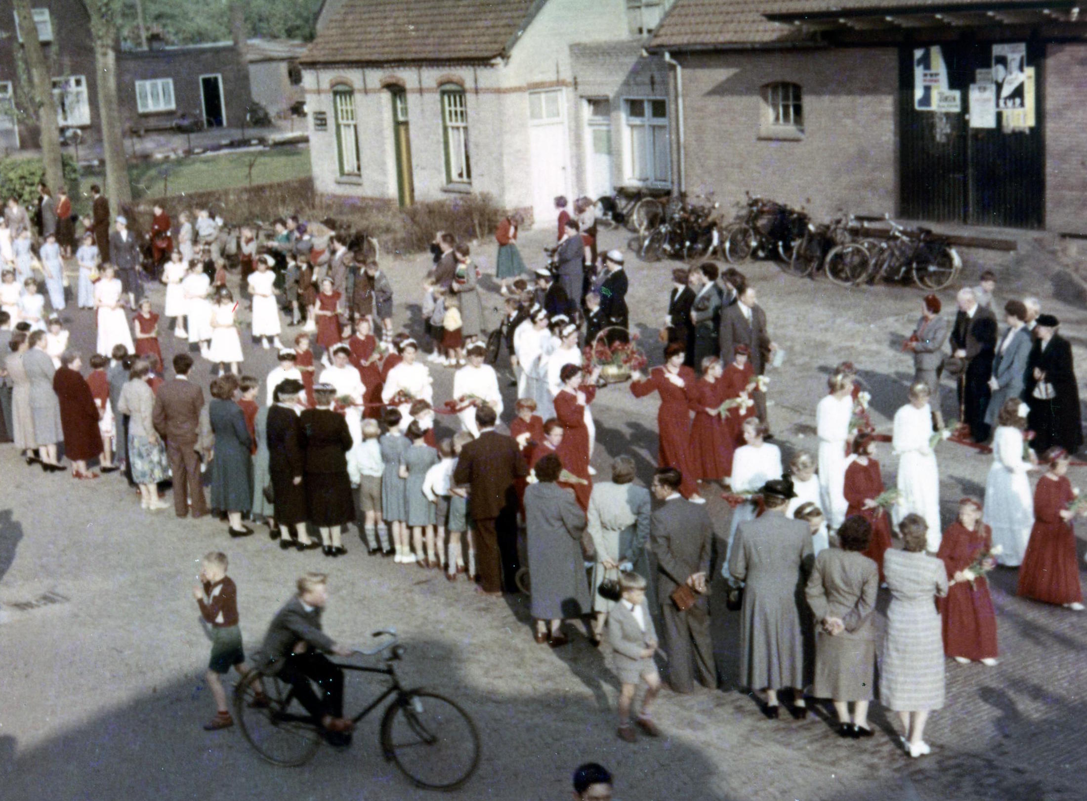 1956. De Maria-omgang trekt voorbij door de Dorpsstraat. Rechts het Boerenbondsgebouw met verkiezingsposters uit 1956 (foto: Noud van de Ven)