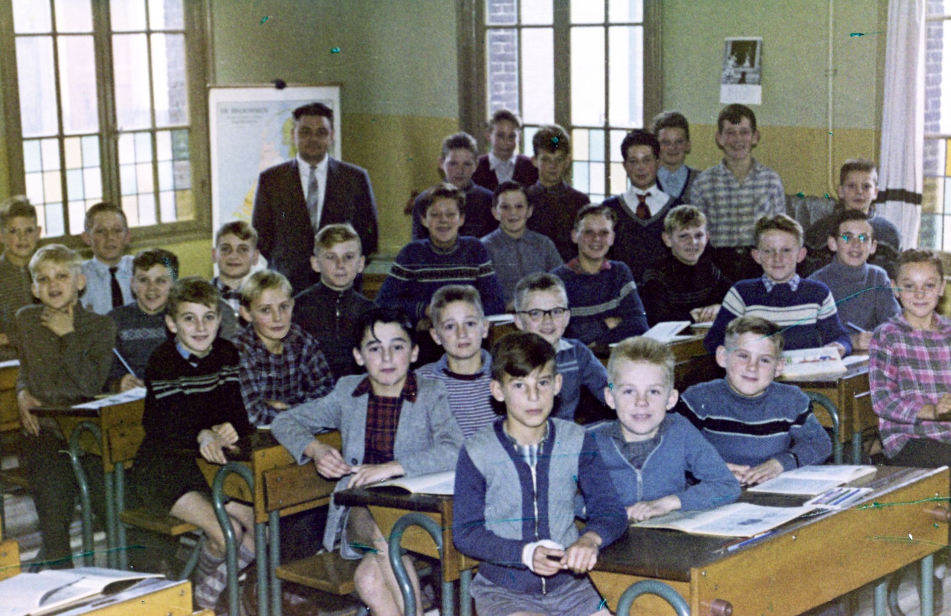 1956. De zesde klas van jongensschool St. Jozef. Met als ‘’schoolhoofd’’ Paul Brok; hij staat achter in de klas. Door de ramen is nog wat straatbeeld van de Dorpsstraat zichtbaar. De namen van de jongens zijn niet bekend (fotograaf onbekend)