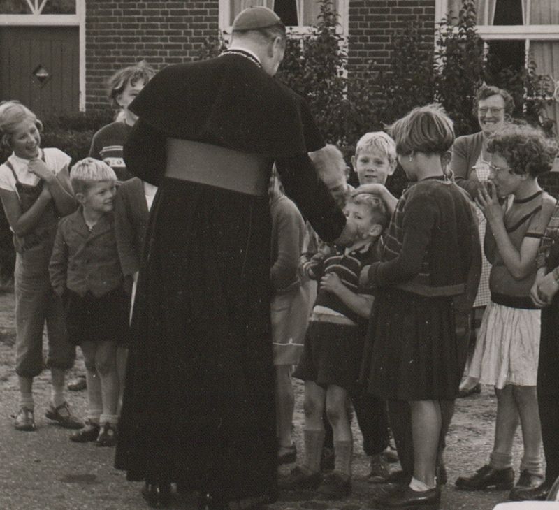 De bisschop tijdens een onderonsje met de buurtkinderen in Sint-Anthonis, 1957