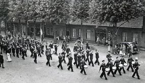 Uden, c. 1950: Harmonie Eendracht marcheert over de Marktstraat. Klik voor een groter beeld.