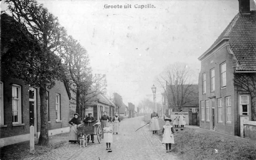 Grotestraat Capelle, met een aantal kinderen en volwassenen met een hondenkar