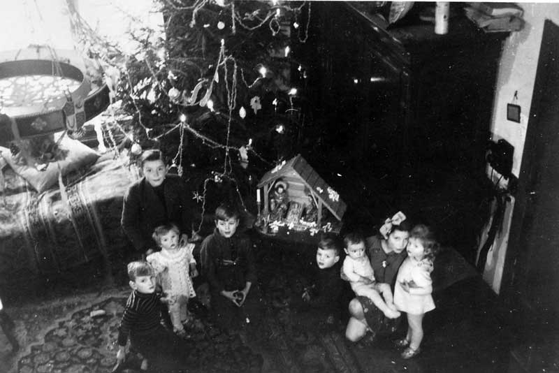 Onbekende kinderen bij een kerstboom en kerststal (foto: Jan Stoop. Bron: BHIC, fotonummer DCVAR-000530)