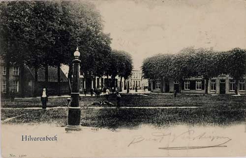 Vrijthof Hilvarenbeek, op de voorgrond een dorpspomp, op de achtergrond de Paardenstraat. Geheel links de N.H. pastorie