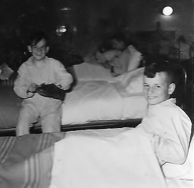 4. Jan en Bert Wijnen op de grote slaapzaal, waarschijnlijk in 1959, tijdens een "stagebezoek" met enkele klasgenootjes uit Heesch. Jan poetst ijverig zijn schoenen.