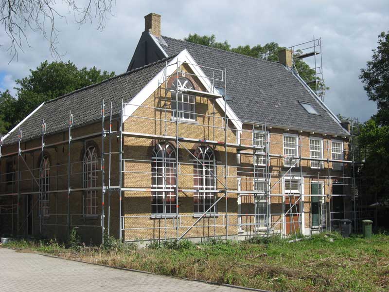 De voormalige pastorie in de steigers t.b.v. de renovatie met links het bijzaaltje (foto: © Johan van der Vlist)