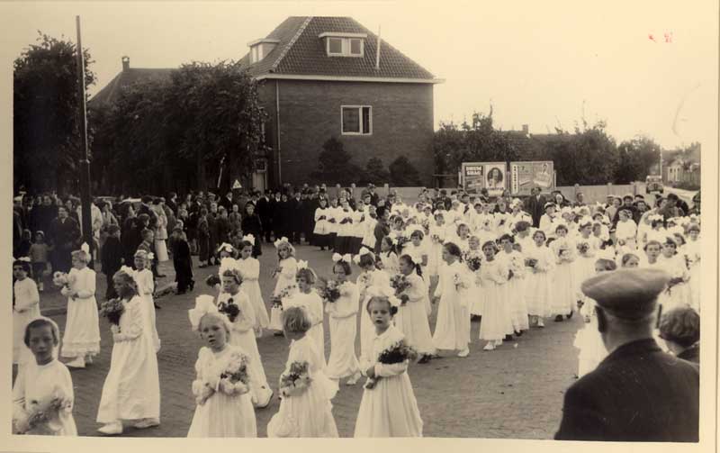 Bij het “inhalen”  van de nieuwe pastoor was er ook en rol weggelegd voor de bruidjes. Via de school werden de meisjes gevraagd om bruidje te zijn. Zoals op de foto is te zien, gaven er vele gehoor aan deze oproep.