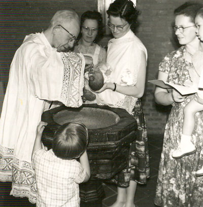Pastoor Van Moorsel tijdens het doopsel