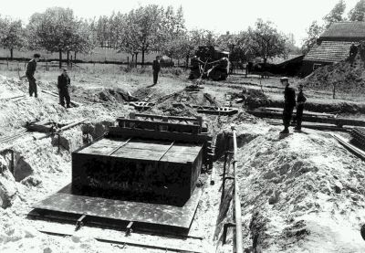 De centuriontank trekt een stalen plaat onder graf VII door