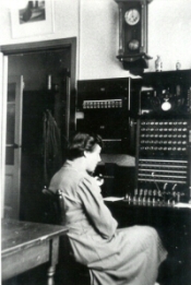 een telefoniste voor het paneel waar de verbindingen tot stand werden gebracht