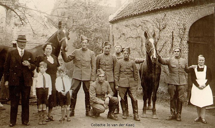 Inkwartiering bij de familie Van de Broek aan de Emmausstraat. Links Hein en Maria van de Broek met de neefjes Cor en Heintje, de zes militairen met twee paarden en Anna van Lieshout (dienstbode), 1939/1940.
