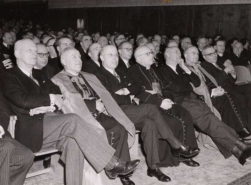 Diesviering in rustiger tijden. Hoogwaardigheidsbekleders luisteren naar de diesrede van prof. Smeets in 1952 (foto: Fotograaf gemeente Tilburg. Bron: Regionaal Archief Tilburg)